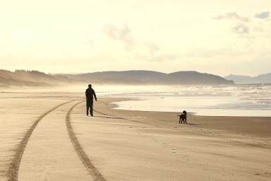 Old man walking down a beach