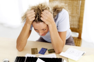 Stressed woman with her head in hands